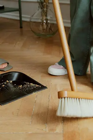 Two people sweeping the floor