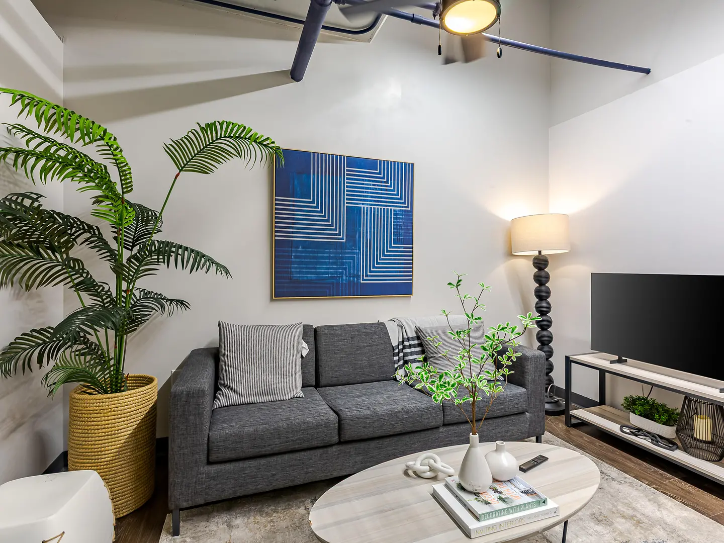 Model living area with a gray sofa and round coffee table.