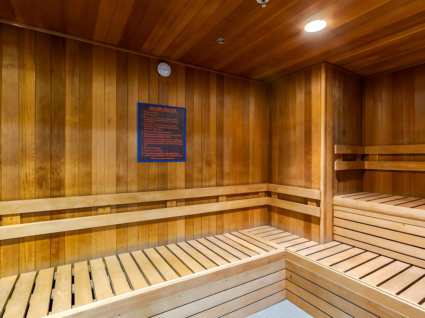 Wood-paneled sauna with tiered benches.