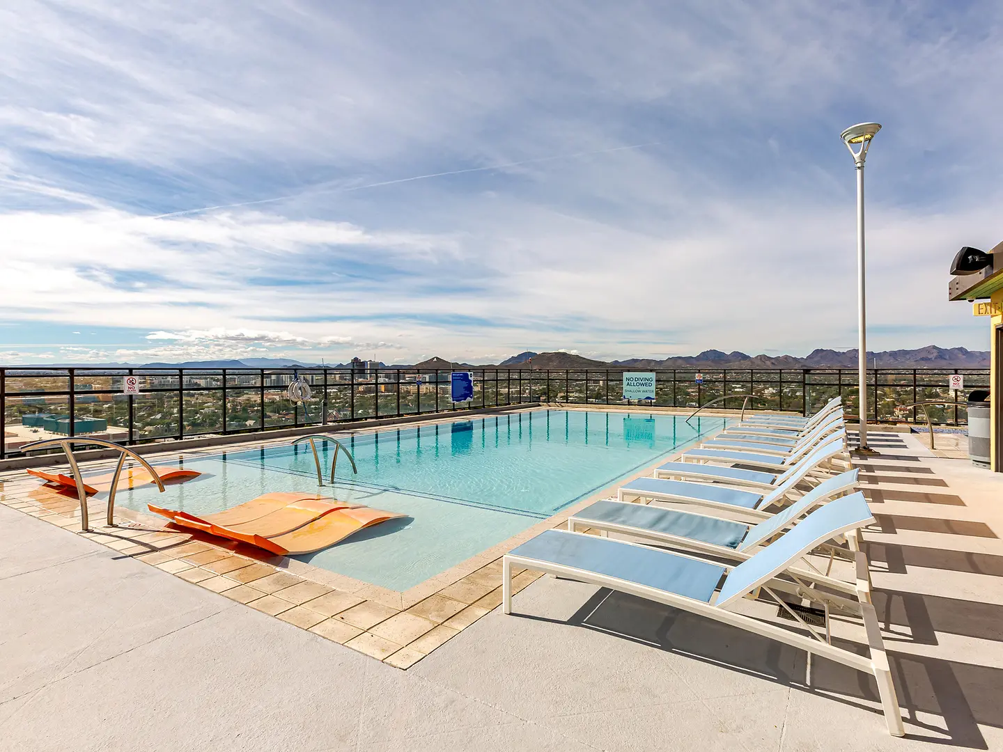 Pool deck with lounge chairs and skyline views.